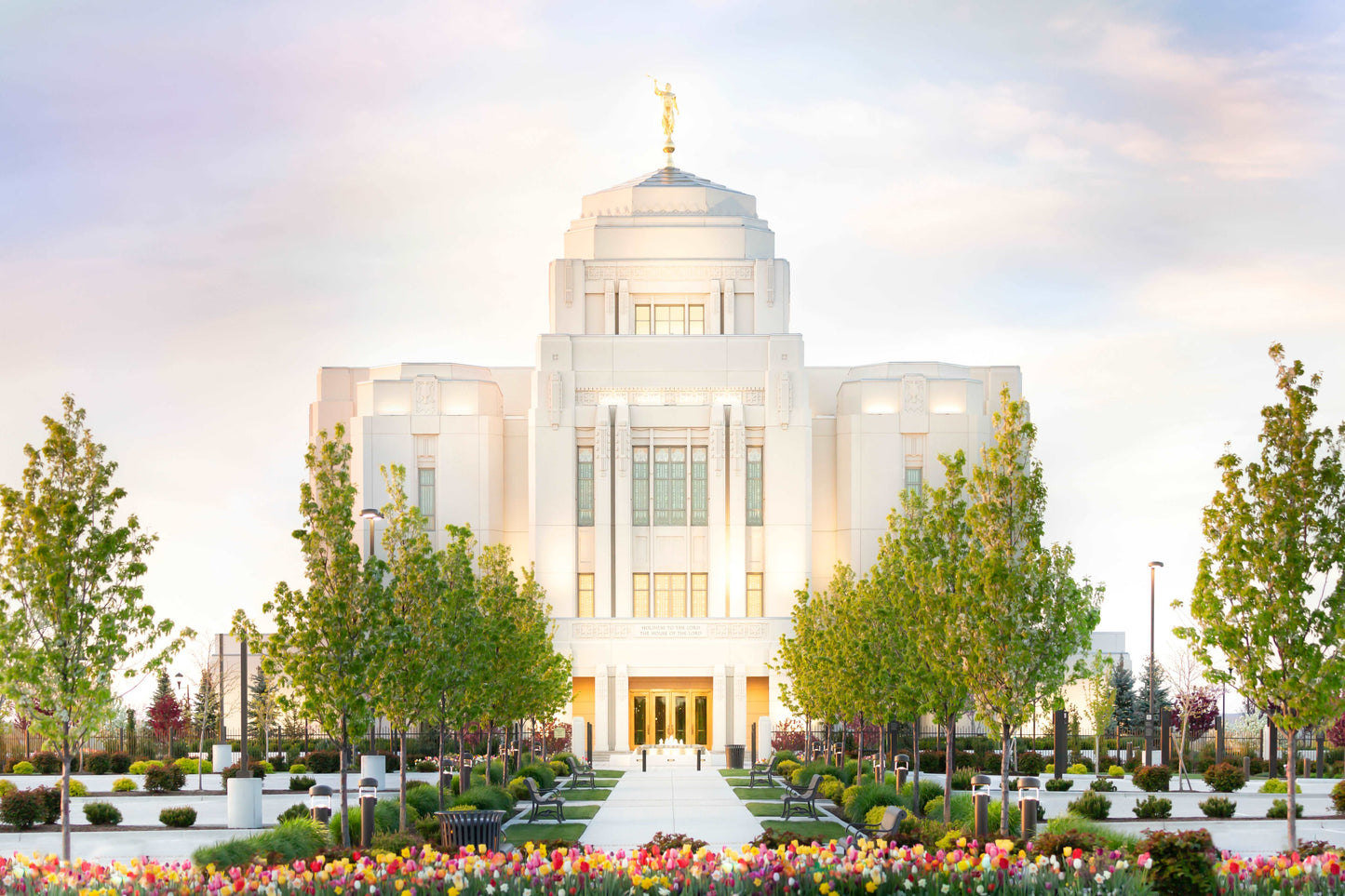Meridian Idaho Temple set in a bed of beautiful spring tulips. Pink, red, yellow dot the foreground in a bright spring of new growth representing the new growth we each experience as we attend the temple and grow with God. Artist- H. Walker @hwphotoart